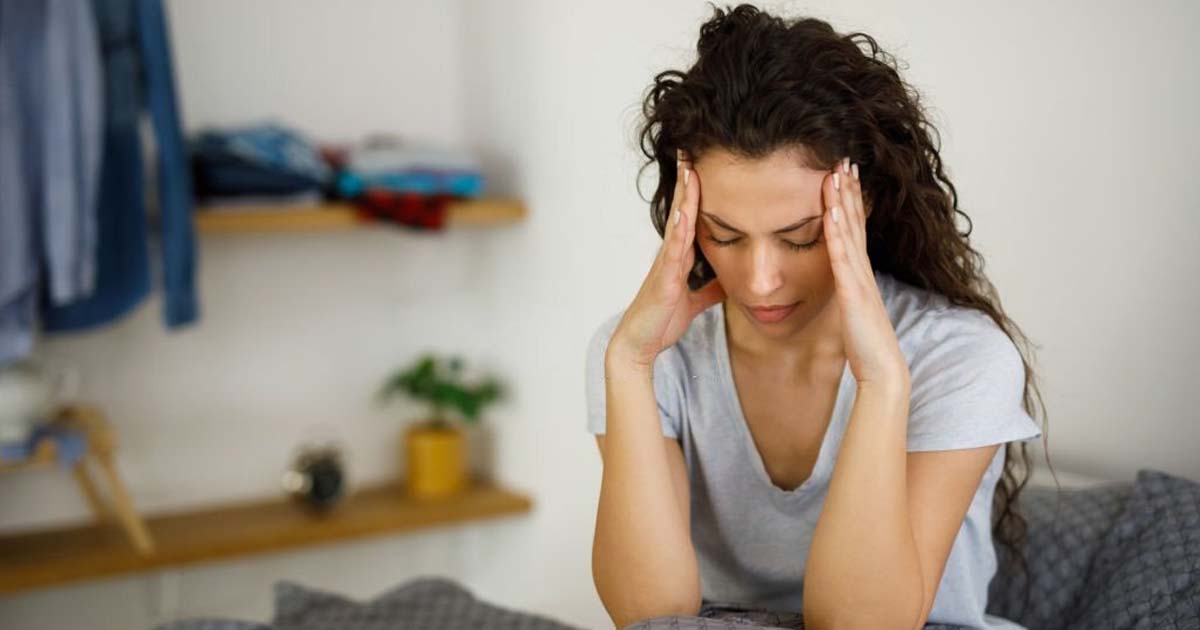 Woman in bed suffering from headache