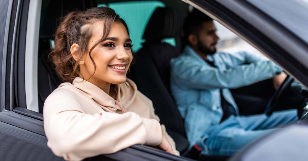 Beautiful young couple sitting on the front passenger seats