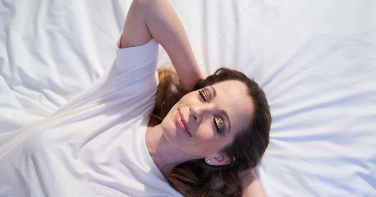 Smiling woman lying in bed