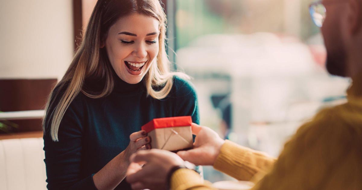 Surprised woman receiving gift box