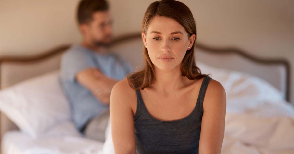 Woman sad sitting on bed