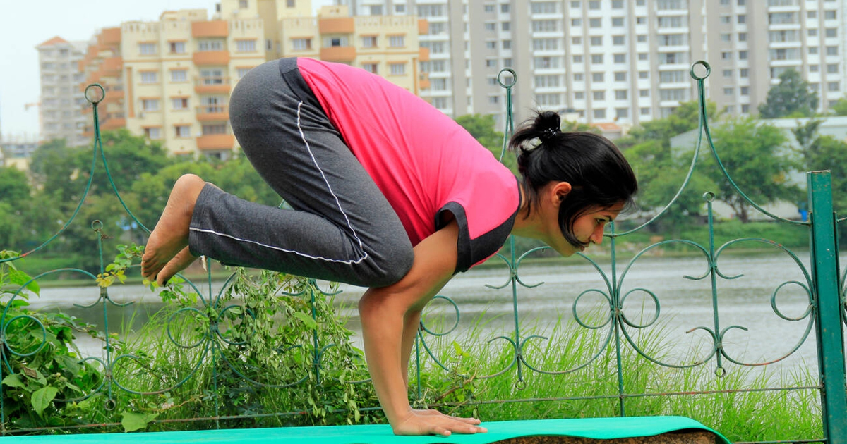 Young Indian woman performing bakasana