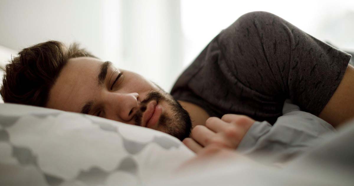 Young man sleeping in bed