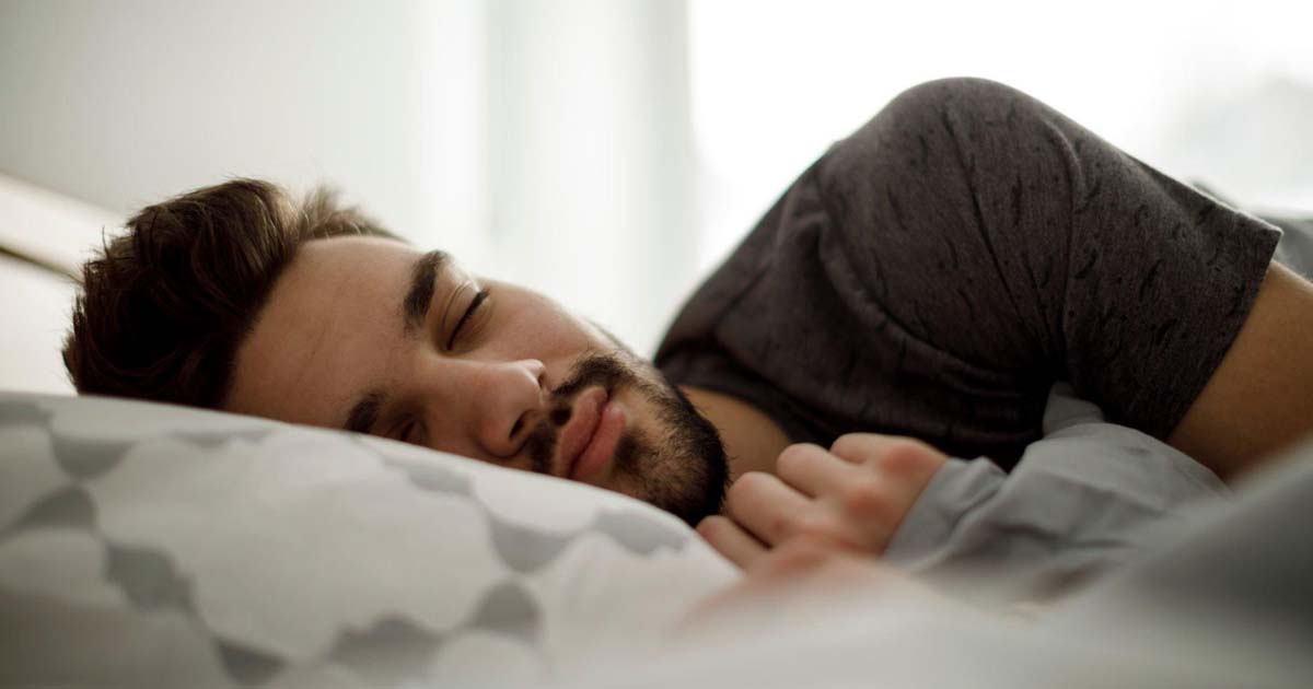 Young man sleeping in bed