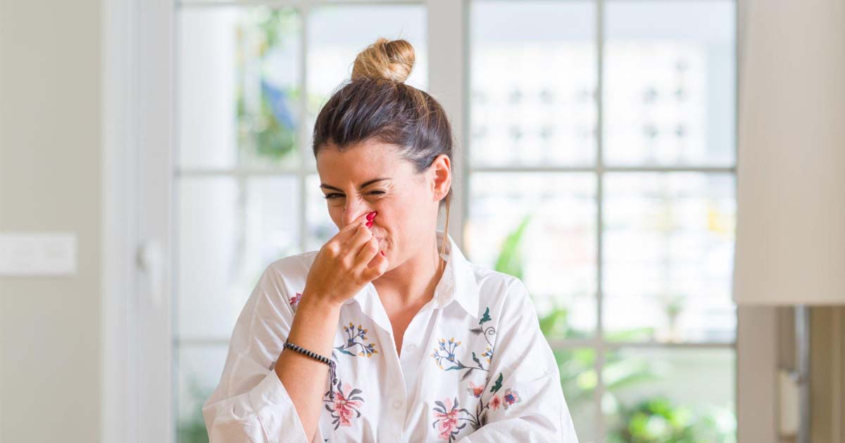 Young woman at home smelling